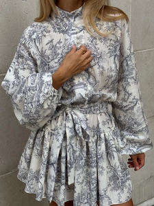 Détails des boutons perlés et de la texture imprimée Toile de Jouy sur la robe à manches