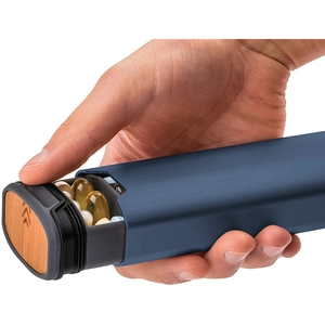 Detail of opening blue aluminum pill box with wooden cap and grey plastic compartments