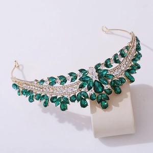 Detail of bridal tiara featuring green and clear crystals set in a golden leaf design