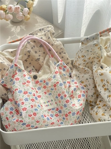Detailed view of floral canvas tote bags with seersucker texture and brand logo