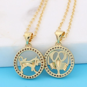 Gold zodiac necklaces featuring Taurus and Cancer pendants on a white marble surface