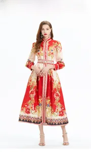 Detail van etnische bloemenprint op lange maxi-jurk met vintage lantaarnmouwen in rood