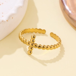 Detailed macro view of an adjustable gold-plated titanium ring with beaded cross design