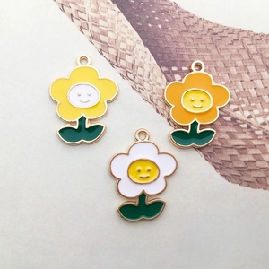 Macro shot of colorful enamel flower pendants with smiley faces for DIY jewelry making