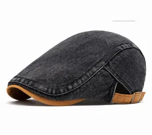 Side view detail of washed denim beret featuring brown contrast brim and metal adjustment buckle