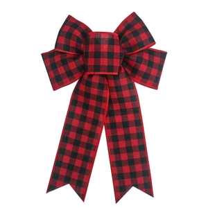 Close-up of red and black buffalo plaid Christmas bow with rustic fabric texture