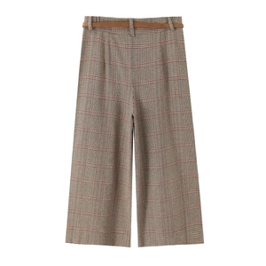 Detail of plaid wide-leg trousers with a slim brown belt and multicolor woven texture