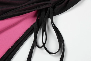 Detail des schwarzen Strickkleids mit magentafarbenem Futter und Kordelzug
