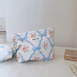 Détail macro de la trousse à maquillage avec nœuds bleus, roses et étiquette simple wish