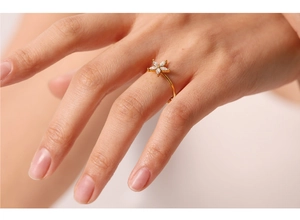 Dettaglio dell'anello a fiore dorato con pietre taglio marquise indossato