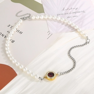 Detail of mixed-style Cuban chain necklace featuring white pearls and a red gemstone pendant
