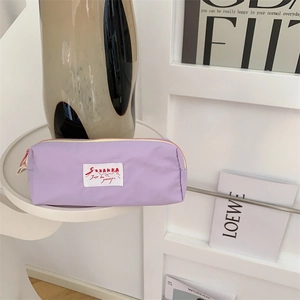 Chic purple pencil case on display with modern ceramic vase and fashion magazine detail