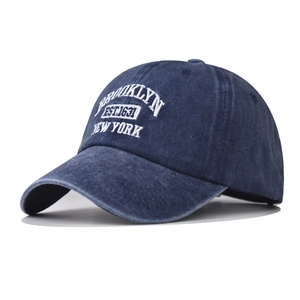 Détail de la broderie blanche Brooklyn sur une casquette en coton bleu marine délavé