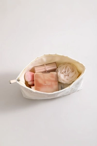 Detail view of heart embroidered white cosmetic bag with open zipper and spacious interior