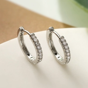 Elegant silver-colored hoop earrings featuring sparkling cubic zirconia on a polished metal base