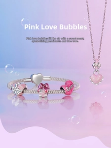 Detail of pink heart gift box charms and silver snake chain bracelet with pearl heart pendant