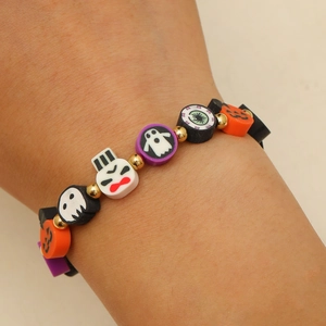 Primer plano de la pulsera de Halloween con dijes de calabaza y fantasma en la muñeca