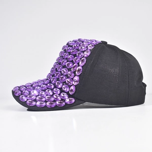 Dettaglio cappello baseball nero con strass viola e decorazioni di lusso scintillanti