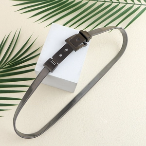 Modern black metal mesh spring belt with square buckle displayed on white cube