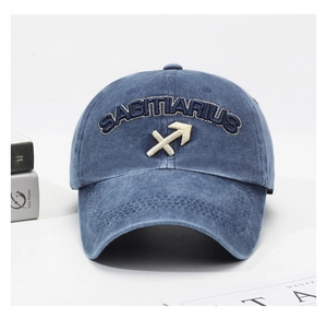 Detail of navy blue washed cotton baseball cap with Sagittarius embroidery on a desk