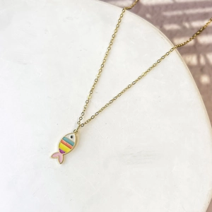 Macro detail of a colorful enamel fish pendant on a delicate gold stainless steel chain