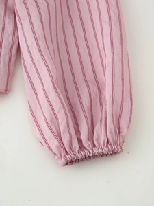 Detailed macro view of pink striped shirt sleeves with elastic ruched cuffs design