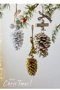 Close-up of pine cone ornaments with gold and silver glitter and rustic hemp ropes