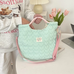 Détail du sac cabas matelassé vert menthe à motifs cœurs avec bandoulière rose et style ins