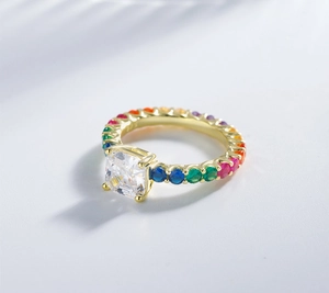 Macro detail of square-cut central diamond with rainbow gemstone side settings