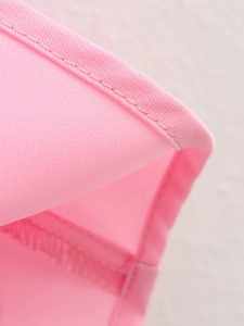Detail of pink fabric showing professional overlock stitching and smooth texture