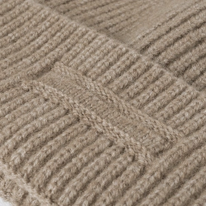 Close-up of thick ribbed jacquard knit beanie in dark camel warm winter fabric