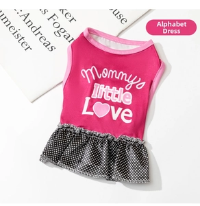 Close-up of pink dog dress featuring polka dot pleated skirt and heart pattern text