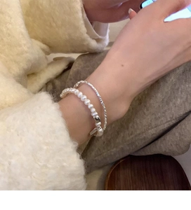 Detailed macro view of S925 silver LUCKY charm bracelet with white freshwater pearls