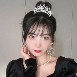 Detail of luxury silver tiara with sparkling rhinestones and pearls on model