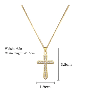 Detail view of a gold cross pendant necklace with clear crystals and sizing measurements