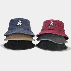 Detail view of cotton bucket hats with palm embroidery in various vintage washed colors