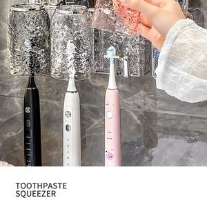 Detail view of wall-mounted toothbrush holder with wavy cups and toothpaste squeezer