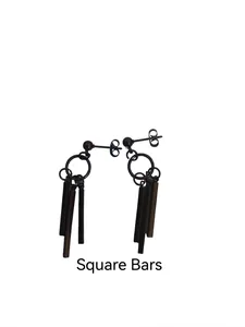 Macro detail of matte black square bar earrings in titanium steel with column pendants