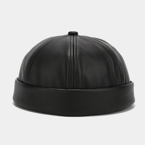 Detailed view of black faux leather texture and stitching on a minimalist docker cap