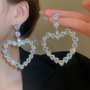 Vue détaillée de grandes boucles d'oreilles cœur évidé serties de strass multicolores