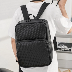 Close-up of the woven leather texture and front zipper pocket on the black backpack