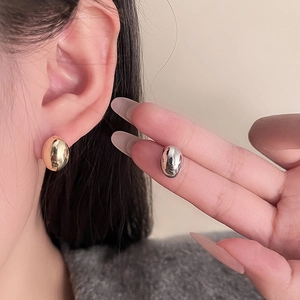 Minimalist metallic bean earrings in gold and silver finish with a polished mirror texture