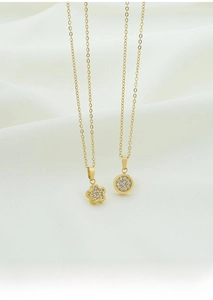 Detail of gold titanium steel necklaces with sparkling zircon flower and round pendants