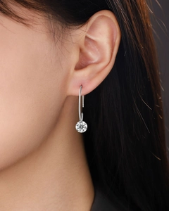 Detail of elegant 925 silver drop earrings with round moissanite stone on female model