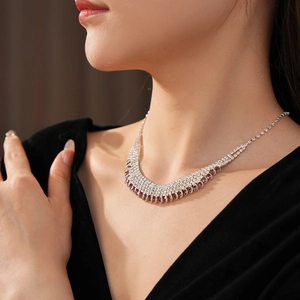Close-up of elegant silver multi-row rhinestone tassel necklace worn on a model's neck
