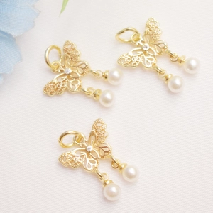 Detail of 14K gold plated butterfly pendant with hollow design and white pearls