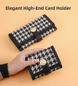 Detail of long and short houndstooth wallets with black leather trim and gold buckles