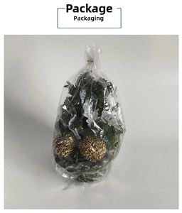 Detail view of mini desktop Christmas tree with red gold baubles in plastic packaging
