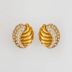 Close-up of vintage gold earrings with emerald green zircon and pave crystals