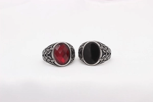Detail of vintage silver men's Viking rings with red and black oval gemstones